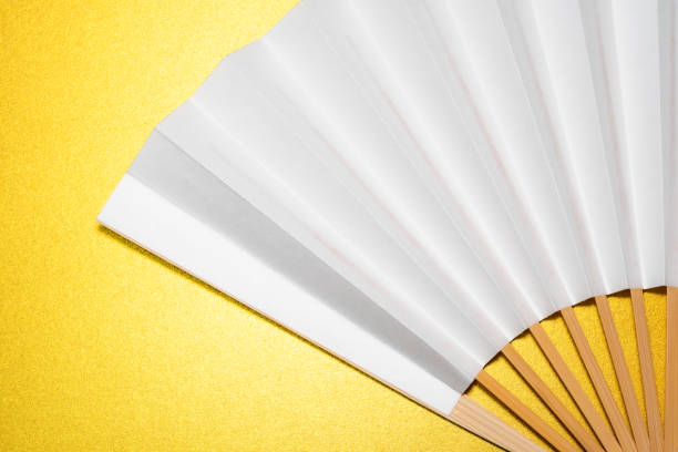 istock whtie Japanese foldable fan on golden background with copy space 1162138995
