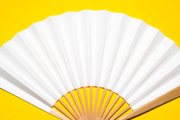 istock whtie Japanese foldable fan on yellow background with copy space 1162139022