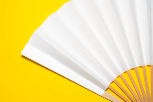 istock whtie Japanese foldable fan on yellow background with copy space 1162139051
