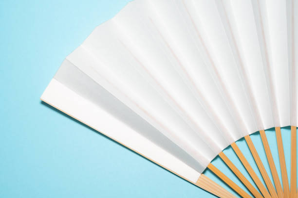 istock whtie Japanese foldable fan on light blue background with copy space 1162139144
