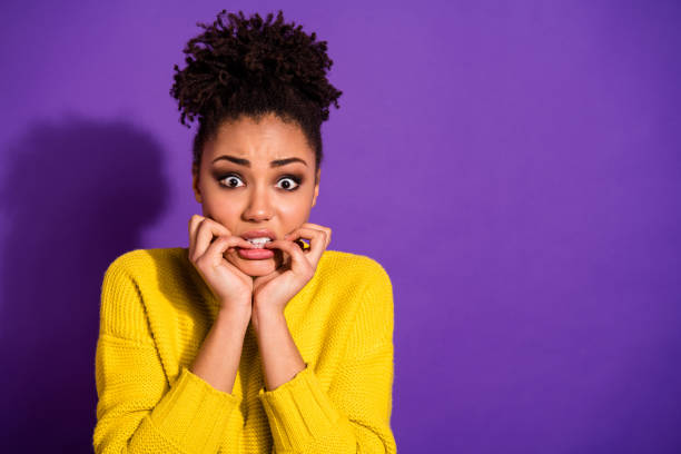 Portrait of terrified beautiful youth nails bite hear horrible news wear stylish trendy pullover jumper isolated over purple violet background Portrait of terrified beautiful, youth nails bite hear horrible news wear stylish trendy pullover jumper isolated over purple violet background black woman hair bun stock pictures, royalty-free photos & images