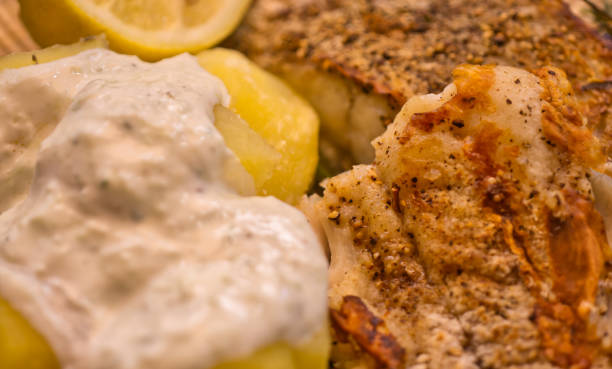 istock Boiled potatoes with light mustard sauce on breaded filet of haddock 1162140716