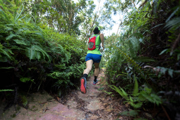 istock Woman ultra marathon runner running on tropical forest trail 1162141030