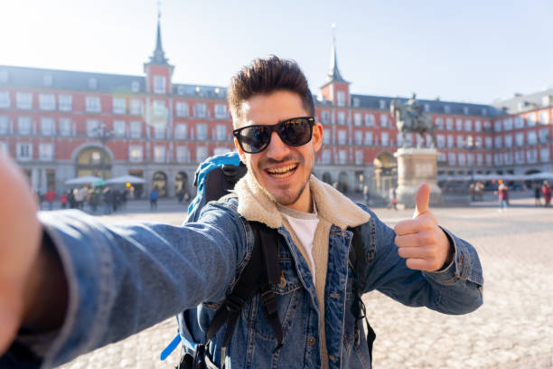 istock Attractive young tourist student man with backpack having fun happy and excited taking a smiling selfie with smart phone in Plaza Mayor, Madrid, Spain. Vacation, and travel around the world concept. 1162141409