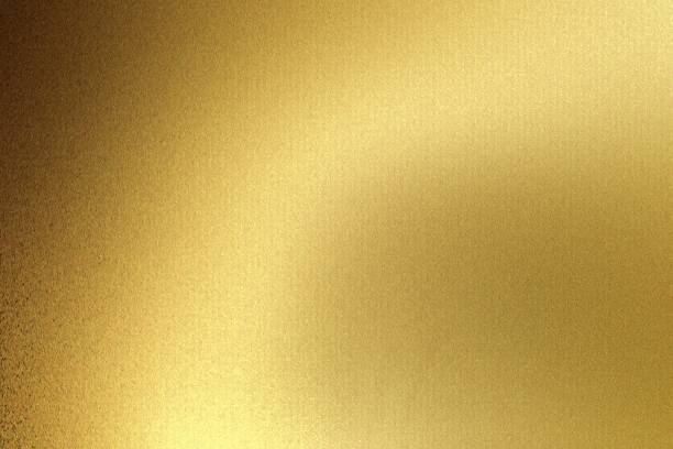 istock Light shining on gold wave metal plate in dark room, abstract texture background 1162142577