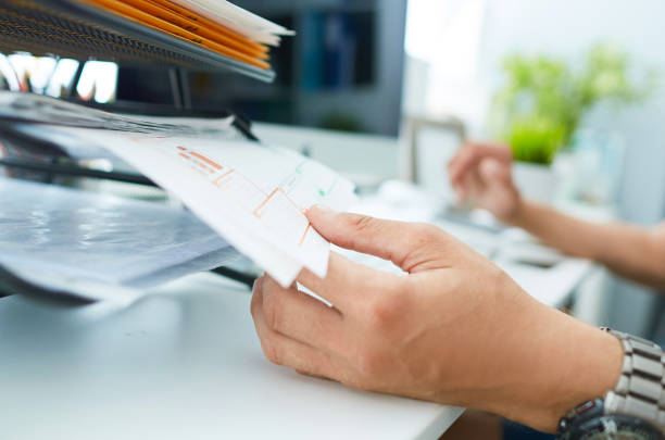 istock Close-up of a man's hand pulling files from office shelves. 1162144492