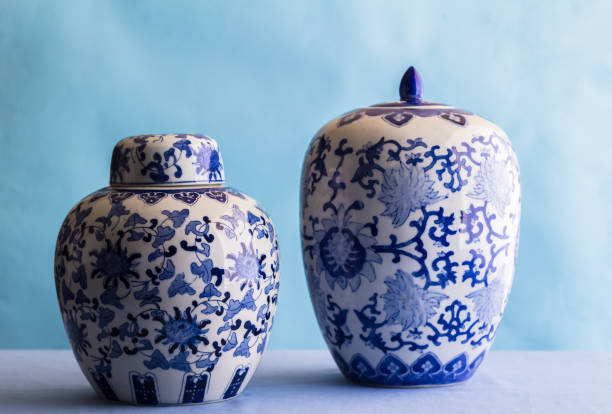 Still life with two blue and white ceramic ginger jars isolated on blue - side view with selective focus