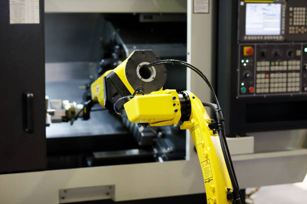 istock robot arm is loading detail into CNC lathe machine 1162146048