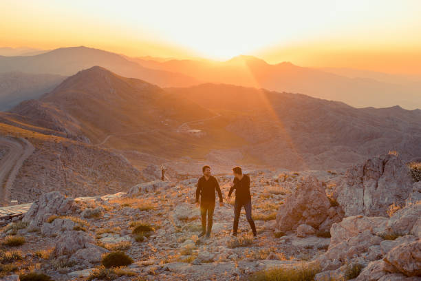 istock Two happy tourists greetings sunrise in mountains 1162147992