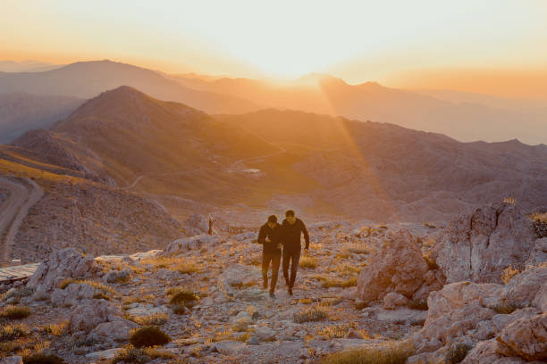 istock Two happy tourists greetings sunrise in mountains 1162148010