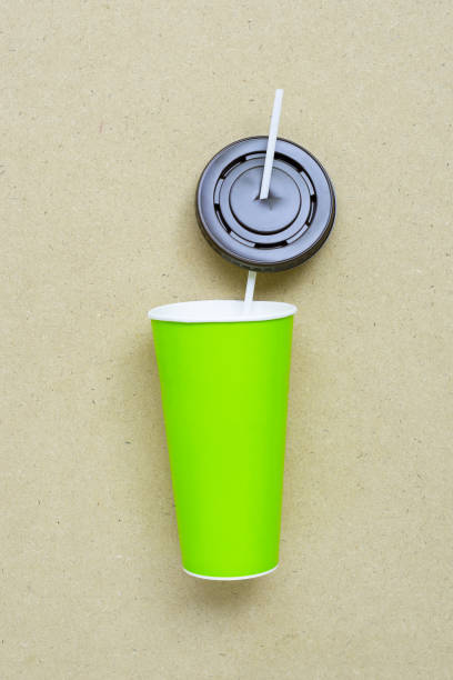 istock Green aper coffee cup with straw and plastic cap on plywood 1162148363