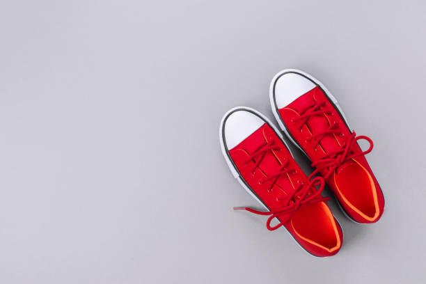 istock New red sneakers on grey background with copy space. 1162149795