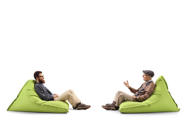 istock Bearded man and a senior man sitting on bean bags and having a conversation 1162149880