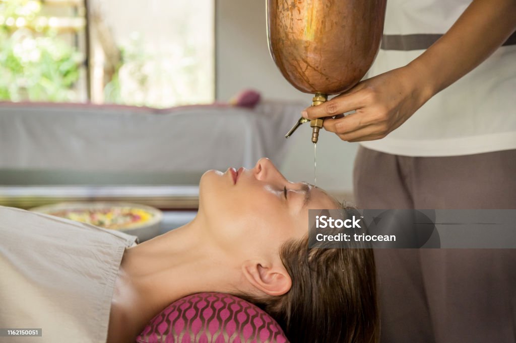 Shirodhara An Ayurvedic Healing Technique Oil Dripping On The Female  Forehead Portrait Of A Young Woman At An Ayurvedic Massage Session With  Aromatic Oil Dripping On Her Forehead And Hair Stock Photo -