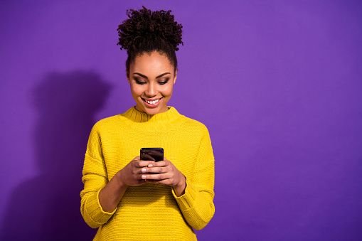 Portrait of her she nice attractive lovely winsome focused cheerful cheery wavy-haired girl holding in hands device chatting on web, isolated over bright vivid shine violet background