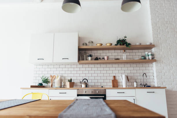 istock Modern new light interior of kitchen with white furniture and dining table. 1162153078