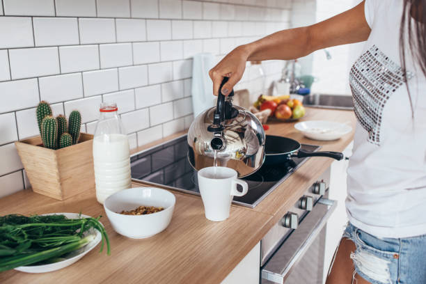 istock Woman pouring boiling water into a cup from kettle. 1162153093