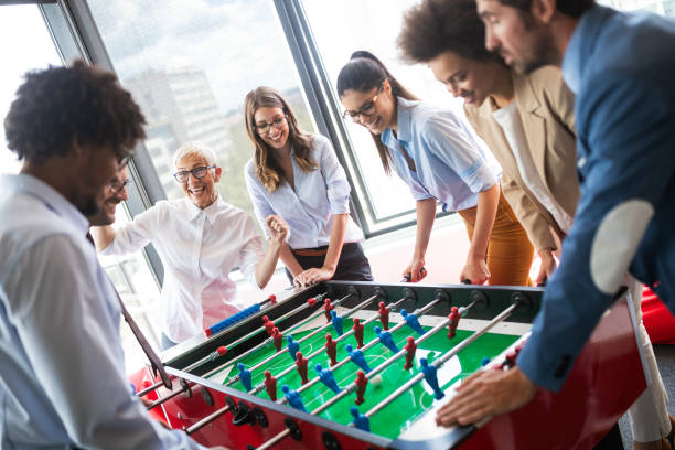 istock Employees playing table soccer indoor game in the office during break time 1162153269