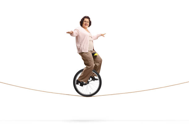 istock Elderly lady riding a unicycle on a rope 1162154787
