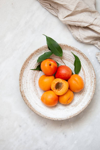 Wicker basket apricot on a marble background with copy space and daylight stock photo