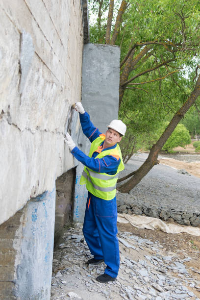 istock a man in a helmet clears a wall of prohibited inscriptions 1162157183