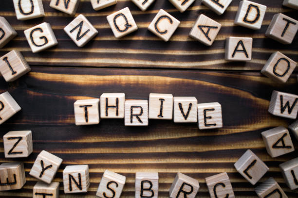 istock word thrive composed of wooden cubes 1162158614