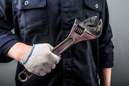 Close-up of plumber hand with wrench. Concept of repair and technical assistance.