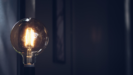 Retro light bulb on dark background with space. Lighting decor macro loft style background. Concept idea
