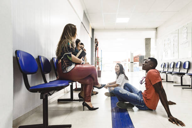 istock Group of students relaxed and sitting on the floor interacting at the University 1162161620