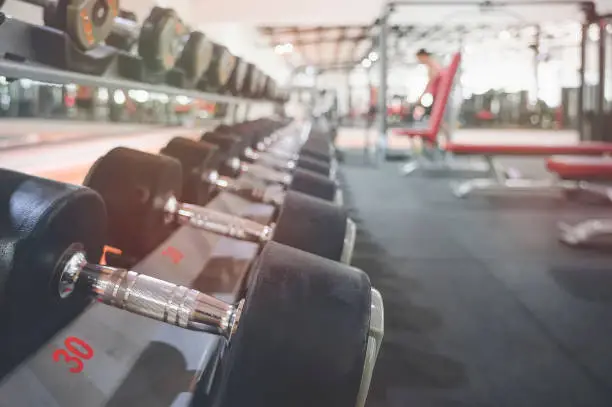 Photo of Close up many metal dumbbells on rack in sport fitness center