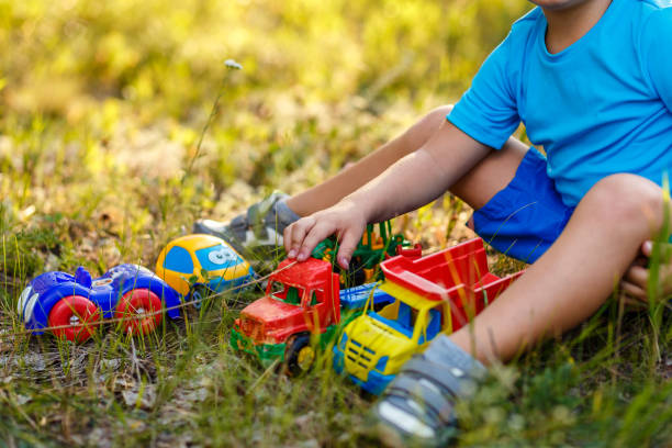 istock Baby plays with plastic machines on the grass 1162162163