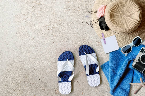 istock Beach background with sandals, straw hat, towel and camera, top view. 1162162226