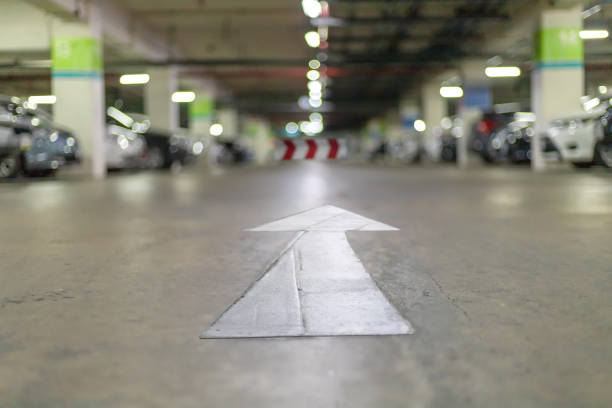 istock Underground parking at supermarket with white arrow sign for exit way. abstract blur image carpark bakcground. 1162162648
