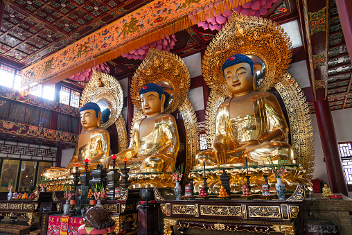 Statues of ancient chinese artistic golden buddhas, in temple of the six banyan trees (Liurong Temple), Guangzhou, China