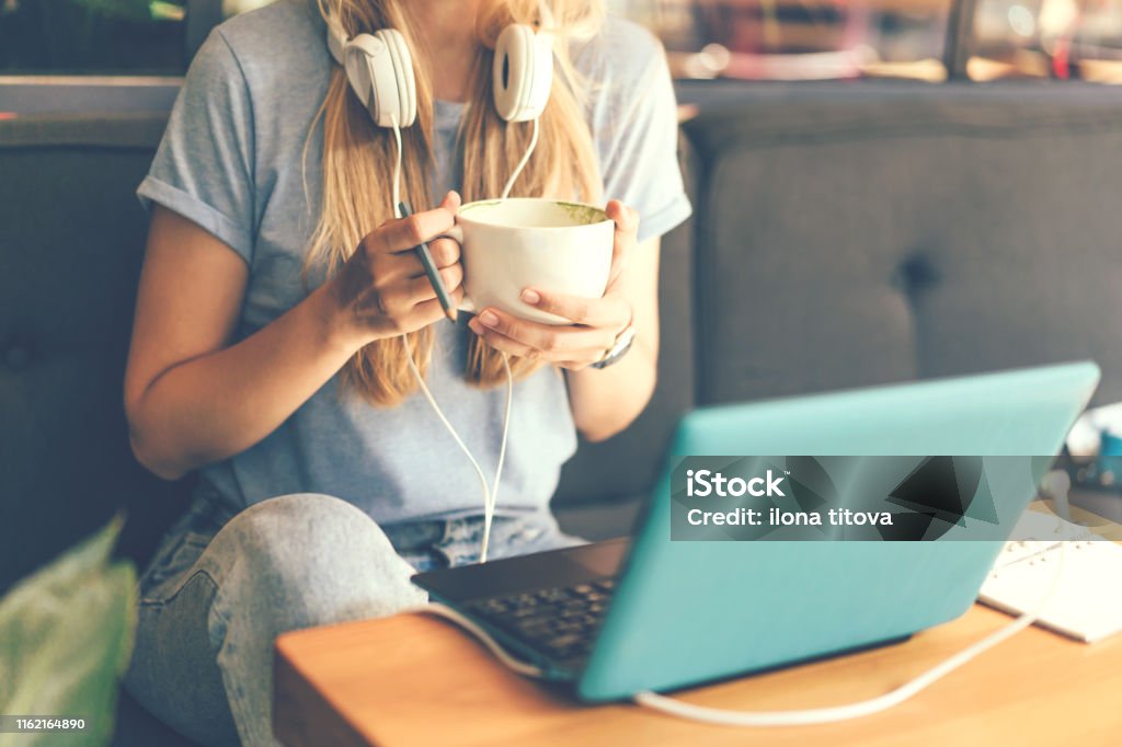 Nahaufnahme eines Mädchens mit Kopfhörern und Laptop - Lizenzfrei Kaffee - Getränk Stock-Foto