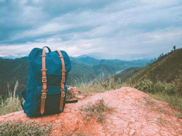 istock camping and travel in tropical forest concept from big blue backpack put on floor with soft focus mountain and copy space background 1162165523