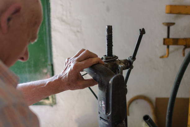istock Carpenter or builder man working wood with electric drill 1162166206
