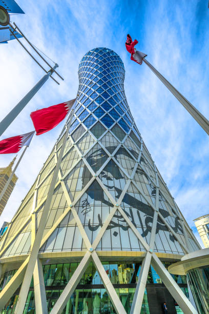 Tornado Tower Doha Doha, Qatar - February 17, 2019: Tornado Tower with image of Emir Tamim bin Hamad al-Thani and Qatar flag, iconic high rise in West Bay. Skyscraper of Financial District in Middle East, Persian Gulf. qatar emir stock pictures, royalty-free photos & images
