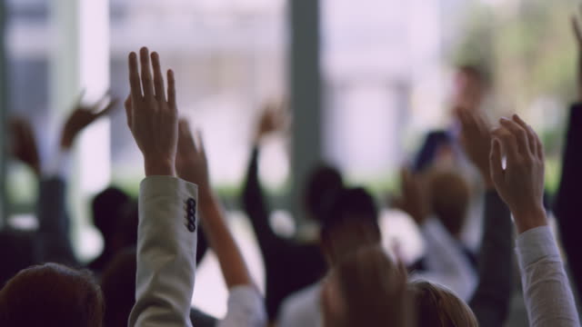Business professionals raising their hands in a business seminar 4k