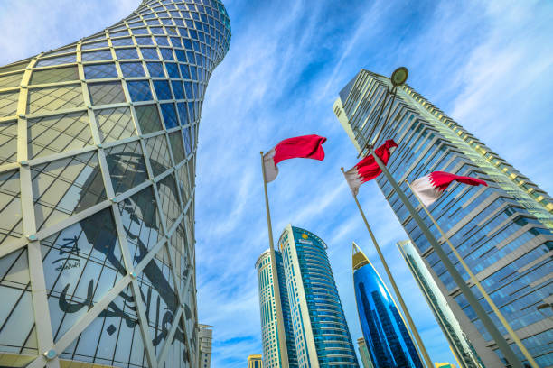 Doha Tornado Tower Doha, Qatar - February 17, 2019: Tornado Tower with image of Emir Tamim bin Hamad al-Thani and Flag of Qatar. High rises in West Bay. Skyscrapers of Financial District in Middle East, Persian Gulf. qatar emir stock pictures, royalty-free photos & images