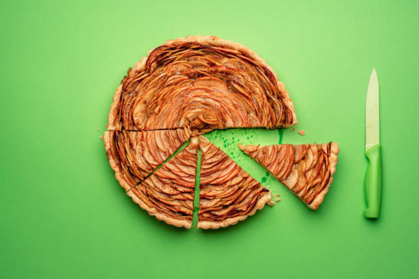 istock Sliced apple pie and knife on green background 1162174065