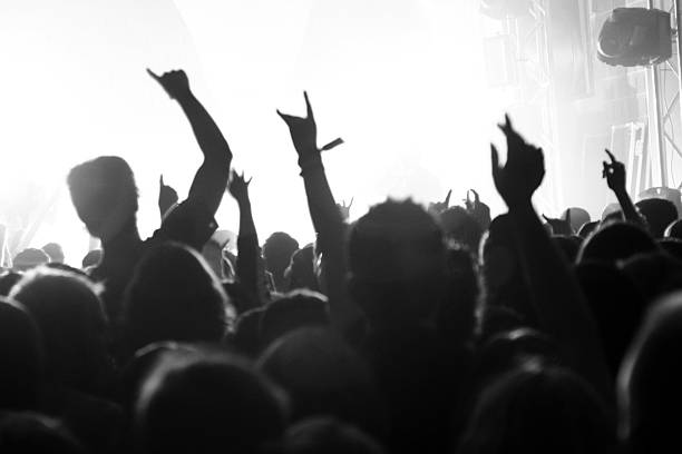istock Silhouettes of people in a crowd with a bright stage 116217609