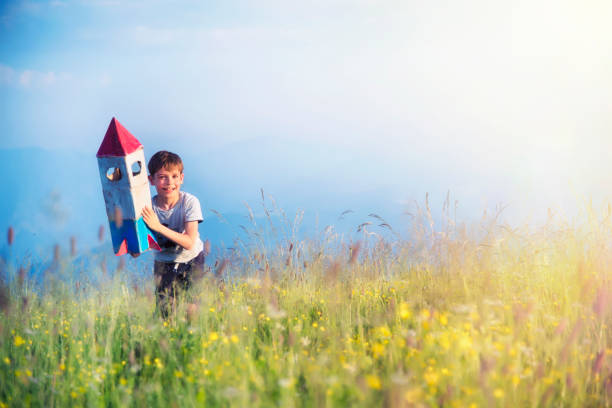 istock Boy Playing with a Toy Space Rocket in the Meadow 1162176135