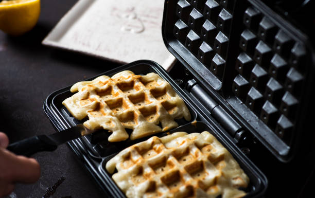 waffles horneando en una máquina de gofres - waffle belgian waffle breakfast fruit fotografías e imágenes de stock