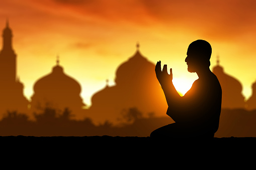 Silhouette of muslim man praying