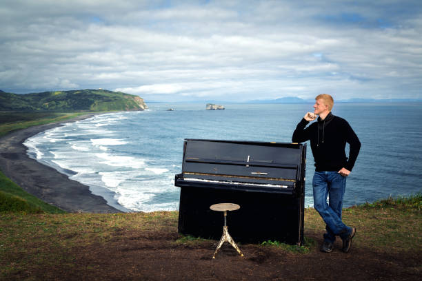 mann am klavier an der küste des pazifischen ozeans - mount misen stock-fotos und bilder