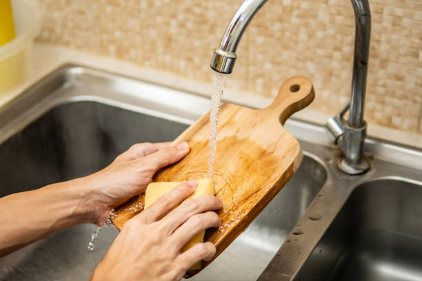 limpieza de la tabla de cortar madera en fregadero de cocina - tabla de cortar fotografías e imágenes de stock