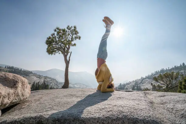 Photo of Young woman exercising yoga from top of Yosemite valley, USA