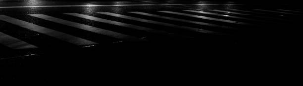 istock Zebra crossing and vehicle headlight reflection in dark night low light black background with copy space 1162184619