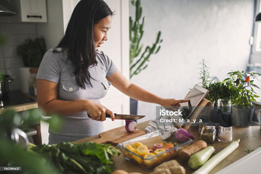 Making healthy meal Asian women at home making healthy meal Cooking Stock Photo